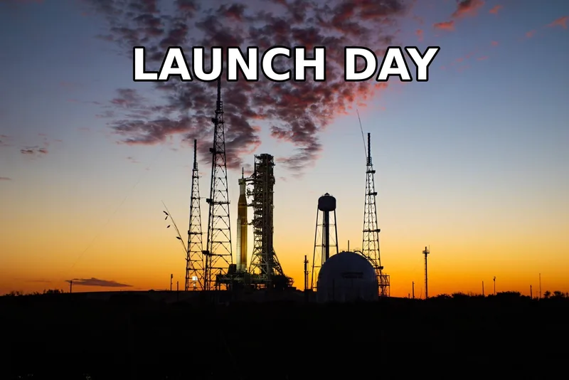 The words LAUNCH DAY in white letters with a black outline over a sunset sky