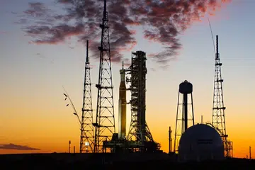 An animation slowly zooming into the rocket on the launch pad at sunset
