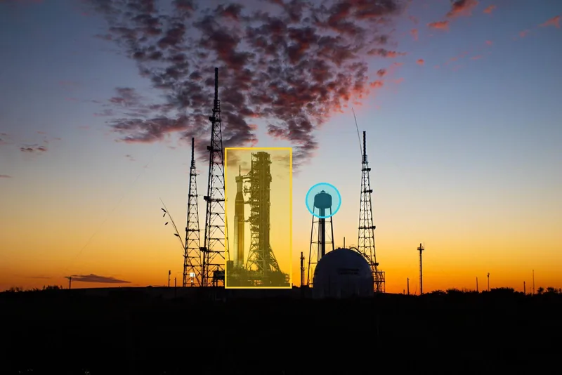 The sunset photo with a translucent yellow box over the rocket and a translucent cyan circle over the water tower